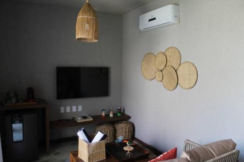 - un salon avec un canapé et une télévision dans l'établissement Casa de luxo na Praia do Patacho - Cond. Azulu, Casa 04, à Porto de Pedras