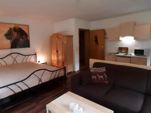 uma sala de estar com uma cama e um sofá em Holiday apartment Africa in the heart of the Harz em Wildemann