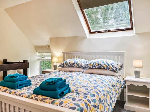 a bedroom with a bed with blue towels on it at Meadow View Cottage in Highpeak Junction