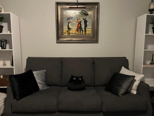 a black cat sitting on a couch in a living room at Little France in Phillipsburg