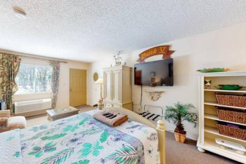 1 dormitorio con 1 cama y TV en la pared en Miami Suite 102 - Tradewinds, en Eureka Springs