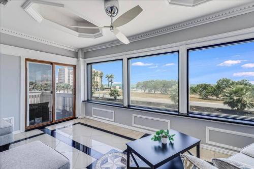 een woonkamer met grote ramen en een tafel bij Ocean View with Private Pool Casa de Joy Dos in Corpus Christi