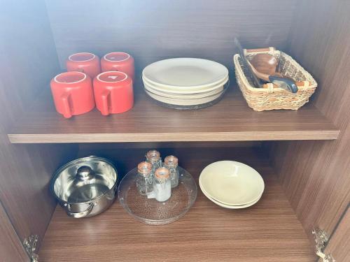 a wooden shelf with plates and dishes on it at Theresa's Homestay in Tawau