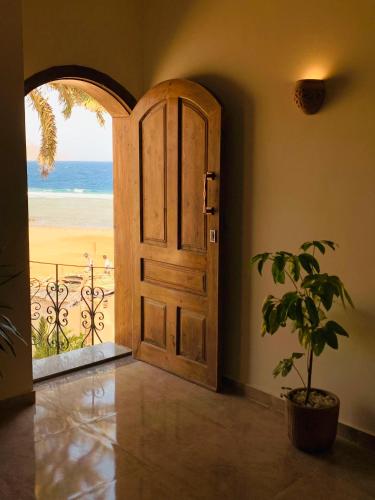 an open door with a view of the beach at Calma Mocha House in Dahab