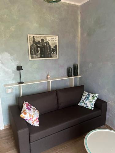 ein Wohnzimmer mit einer schwarzen Couch in einem Zimmer in der Unterkunft Al Buffardel in Bagnone