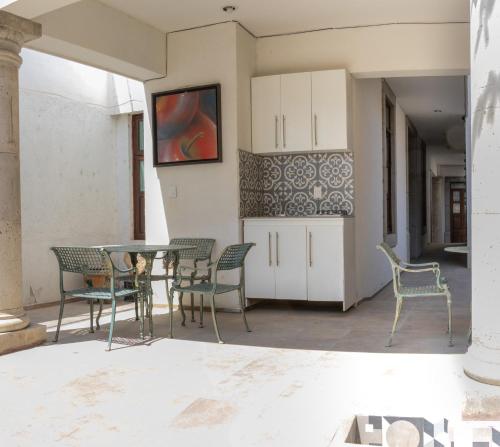 un patio con sillas y una mesa en una habitación en Casa De Los Remedios Morelia en Morelia