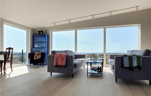 a living room with couches and chairs and large windows at Beautiful Home In Bremnes With Wifi in Bremnes