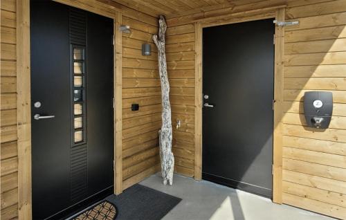 een kamer met twee deuren en een boomstam aan de muur bij Beautiful Home In Bremnes With Wifi in Bremnes
