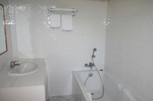 a white bathroom with a shower and a sink at Le Refuge Orezza in Piedicroce