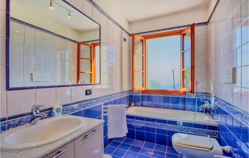 a blue and white bathroom with a sink and a tub at Beautiful Home In Recco With Kitchen in Recco