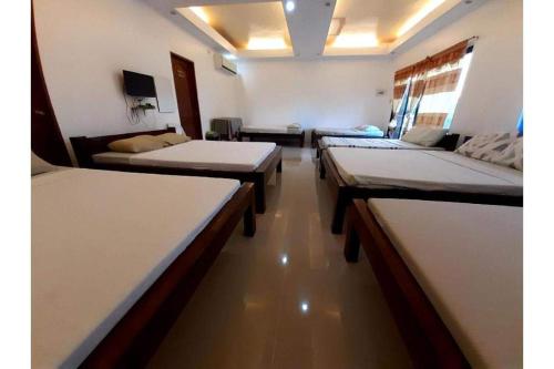 a room with four beds and a couch at LaVeranda Beach Resort in Dauis