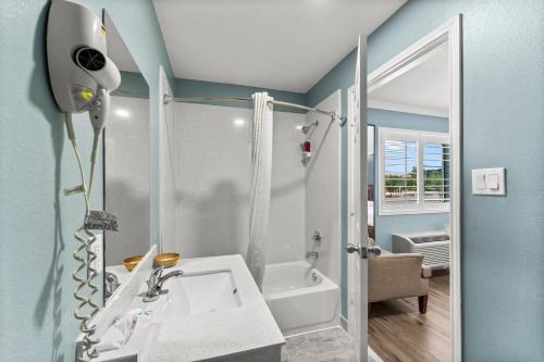 een badkamer met een witte wastafel en een douche bij Executive Inn & Suites Magnolia in Magnolia