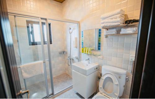 a bathroom with a toilet and a shower and a sink at Na Jie 17 in Donghe