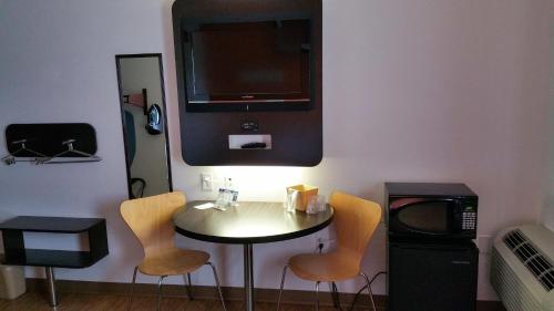 a small table with two chairs and a tv at Motel 6-Eagle Pass, TX - Lakeside in Eagle Pass