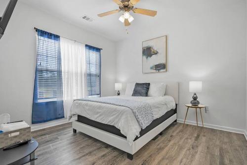 een witte slaapkamer met een bed en een plafondventilator bij 2 Bedroom Apartment near NAS Jax Base in Jacksonville
