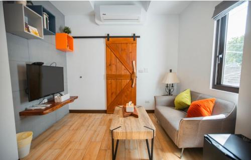a living room with a couch and a tv and a door at Na Jie 17 in Donghe