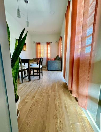 a living room with a wooden floor and a table at Grey Stone Villa 2 in Happy Hill