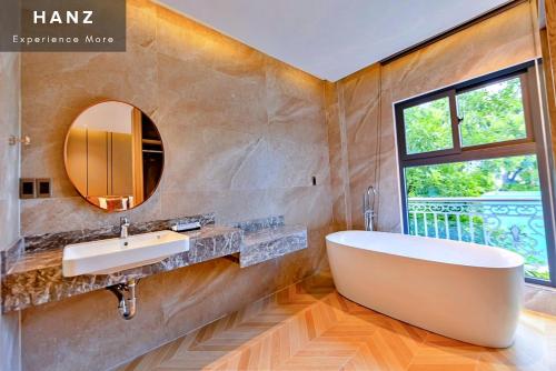 baño con bañera, lavabo y ventana en HANZ MyMy 2 Hotel en Ho Chi Minh