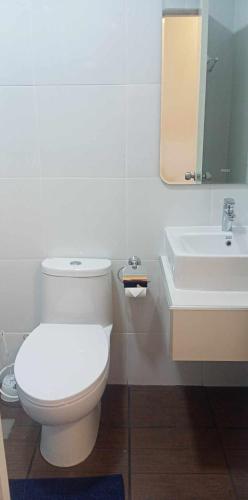 a bathroom with a white toilet and a sink at MAMORI HOTEL in Allen
