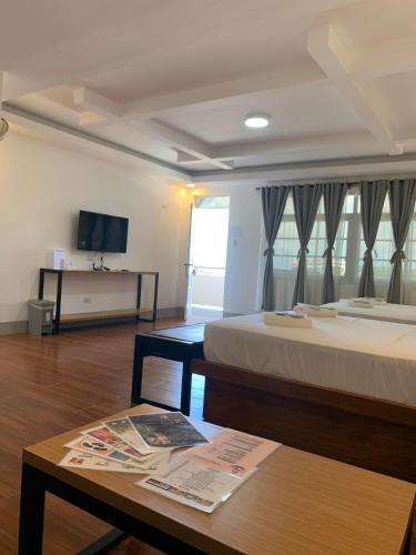a room with two beds and a table and a tv at MAMORI HOTEL in Allen