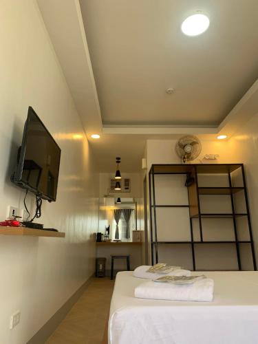a bedroom with a bed with a tv on the wall at MAMORI HOTEL in Allen