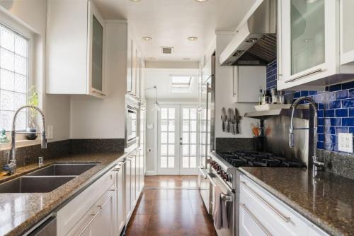 a kitchen with white cabinets and a sink and a stove at 4221 Urban oasis in Hillcrest Mission Hills in San Diego