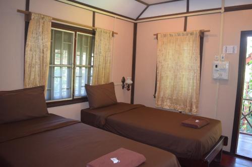 a room with two beds and a window at Namsong Bridge Bungalows in Vang Vieng