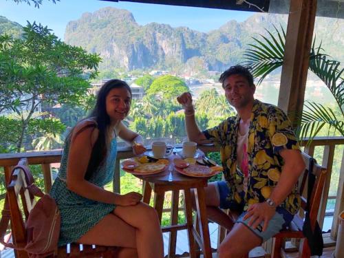 a man and a woman sitting at a table at BaleCabugaoCottagesRental in El Nido