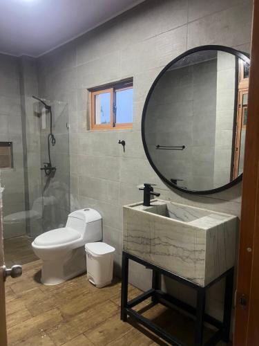 a bathroom with a sink and a toilet and a mirror at Villas regazó de paz, ven a buscar tu paz en la naturaleza in Concepción de La Vega
