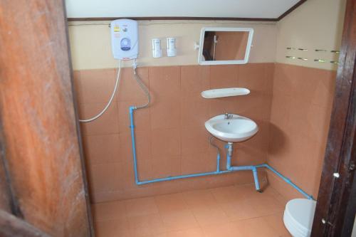 ein kleines Bad mit einem Waschbecken und einem WC in der Unterkunft Namsong Bridge Bungalows in Vang Vieng