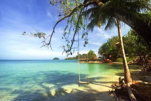 une balançoire suspendue à un palmier sur une plage dans l'établissement Tropical Paradise Leelawadee Resort, à Ko Chang
