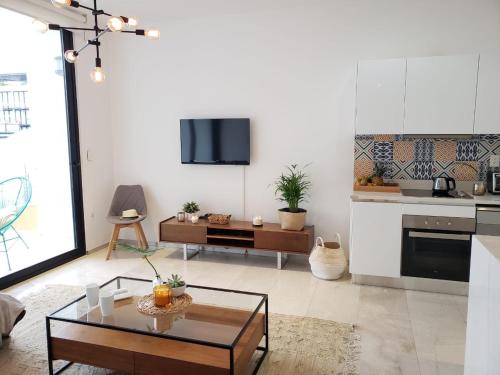 a living room with a table and a kitchen at Luxury 5th Avenue Menesse 32 in Playa del Carmen