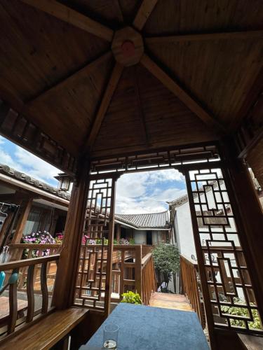 a view from the inside of a pavilion with a table at 夕露小榭星期六南门广场店XILUXIAOXIE Saturday in Lijiang