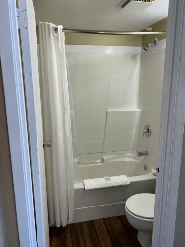 uma casa de banho com uma banheira, um WC e um chuveiro em Goodknight Inn em Lloydminster
