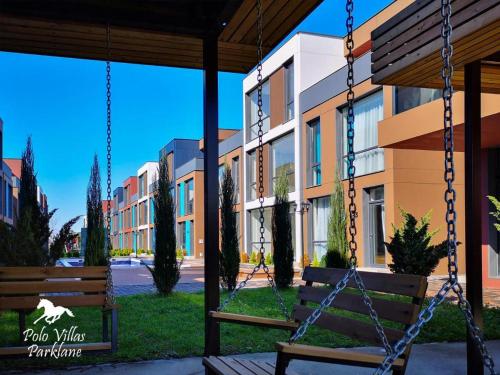 a swing in front of a building at Liana Polo Villas Parklane in Batumi