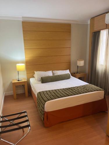 a bedroom with a large bed with a wooden headboard at Hotel lindo Aeroporto Congonhas com garagem e piscinas 1703 in Sao Paulo