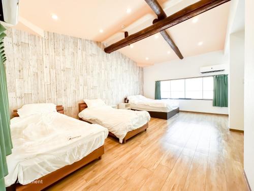two beds in a room with wood floors at Z Apartment大阪 環球影城 USJ 一戶建 歡迎二人入住 in Osaka