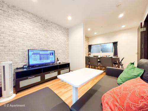 a living room with a tv and a brick wall at Z Apartment大阪 環球影城 USJ 一戶建 歡迎二人入住 in Osaka
