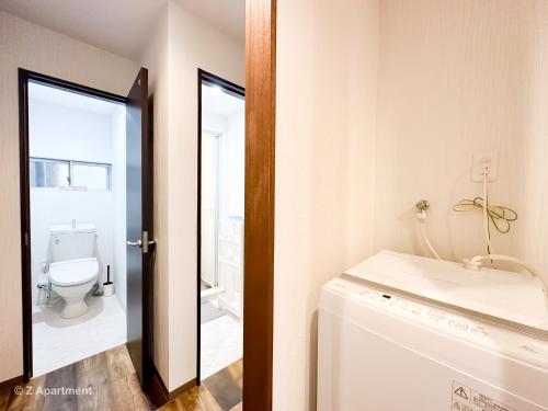a bathroom with a toilet and a sink and a mirror at Z Apartment大阪 環球影城 USJ 一戶建 歡迎二人入住 in Osaka