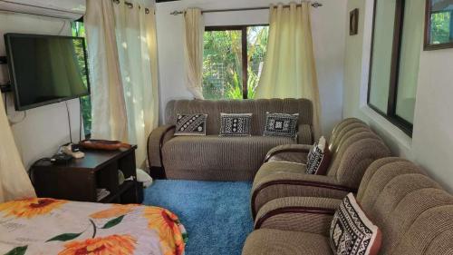 ein Wohnzimmer mit 2 Sofas und einem Flachbild-TV in der Unterkunft Marys Cottage 