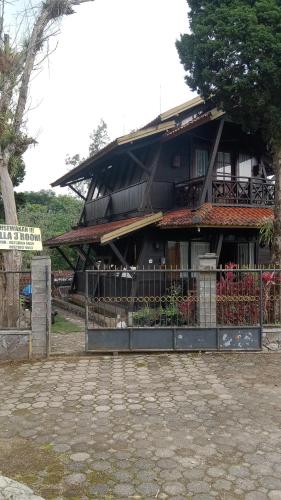 budynek z płotem przed nim w obiekcie villa kayu argapuri resort ciwidey w mieście Pengalongan