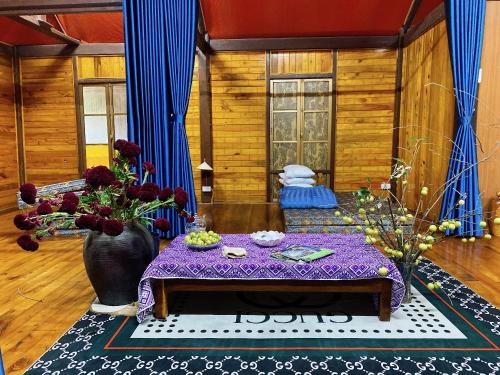 a living room with a table with a purple table cloth at Homestay Chinh Bi in Yên Bái