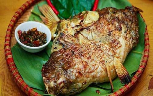 a plate of food with a fish on a table at Homestay Chinh Bi in Yên Bái