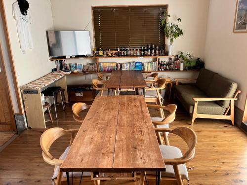 a group of tables and chairs in a room at Goto Backpackers Pole in Shinkamigoto