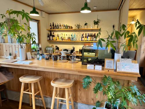 a bar in a restaurant with two stools at Goto Backpackers Pole in Shinkamigoto