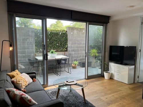 a living room with a couch and a sliding glass door at Centrepoint Units Heidelberg in Melbourne