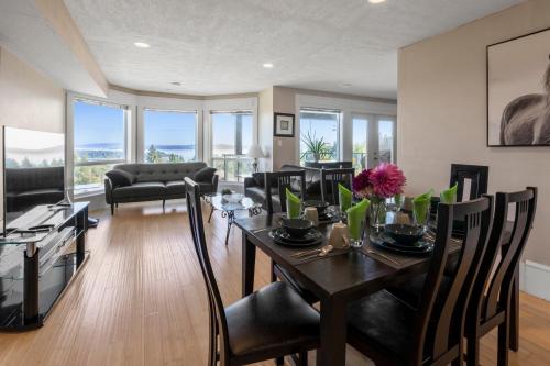 a living room with a dining room table and chairs at Executive pet friendly lower suite with ocean view in Ladysmith