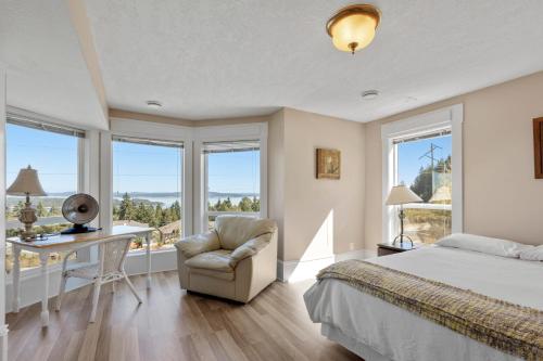 1 dormitorio con cama, escritorio y silla en Executive pet friendly lower suite with ocean view en Ladysmith