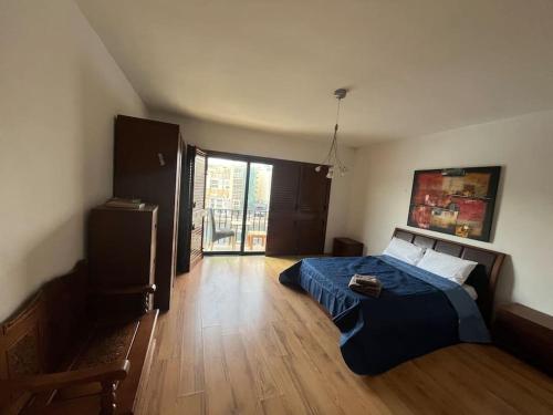 1 dormitorio con 1 cama con edredón azul en 4 bedroom seafront apt St Julian’s, en San Julián
