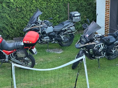 two motorcycles parked on the grass next to a fence at Apartmány MK u MODRÉ KOČKY in Nové Hrady
